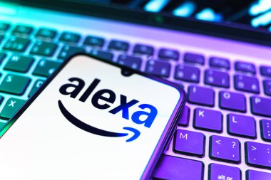 Prag, Çek Cumhuriyeti - 08 19 2025: Klavyenin üzerinde Alexa logosunu gösteren cep telefonunun yakın çekim görüntüsü. Alexa akıllı aygıtlar ve servisler için ses asistanıdır.