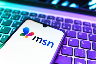 Prag, Çek Cumhuriyeti - 08 19 2025: MSN logosunu gösteren klavyenin üzerinde duran cep telefonunun yakından görüntüsü. MSN haber, e-posta ve çevrimiçi hizmetler için bir platformdur.