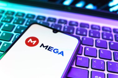 Prag, Çek Cumhuriyeti - 08 19 2025: Klavyede duran ve Mega logosunu gösteren cep telefonunun yakından görüntüsü. Mega şifreli dosya paylaşımı ile bulut depolama platformu.