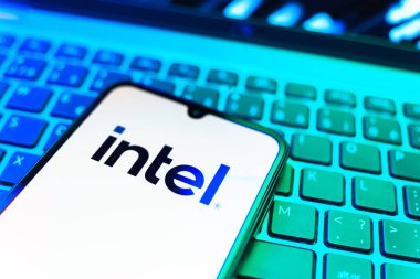 Prag, Çek Cumhuriyeti - 08 19 2025: Intel logosunu gösteren klavyenin üzerinde duran bir cep telefonunun yakından görüntüsü. Intel işlemci ve bilgisayar donanımı üreten bir teknoloji şirketidir..