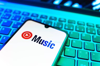 Prag, Çek Cumhuriyeti - 08 19 2025: Bir klavyenin üzerinde duran ve Youtube Müzik logosunu gösteren cep telefonunun yakından görüntüsü. Youtube Music müzik için bir platformdur..