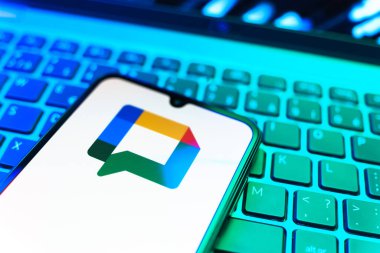 Prag, Çek Cumhuriyeti - 08 19 2025: Google Chat logosunu gösteren klavyenin üzerinde duran cep telefonunun yakından görüntüsü. Google Chat mesajlaşma ve takım işbirliği için bir platformdur.
