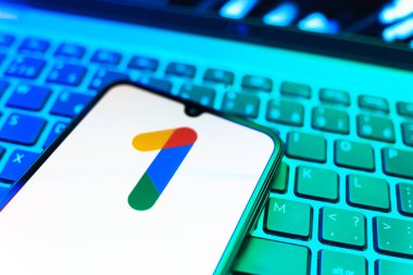 Prag, Çek Cumhuriyeti - 08 19 2025: Bir klavyenin üzerinde duran ve Google One logosunu gösteren cep telefonunun yakından görüntüsü. Google 1 bulut depolama ve abonelik hizmetleri için bir platformdur.