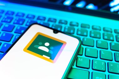 Prag, Çek Cumhuriyeti - 08 19 2025: Google Sınıfı logosunu gösteren klavyenin üzerinde duran cep telefonunun yakından görüntüsü. Google Sınıfı, sınıfları ve eğitim içeriğini yönetmek için bir platformdur.