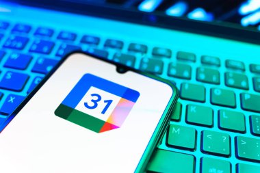 Prag, Çek Cumhuriyeti - 08 19 2025: Google Takvim logosunu gösteren klavyenin üzerinde duran cep telefonunun yakından görüntüsü. Google Takvimi olayları zamanlamak ve yönetmek için bir platformdur.