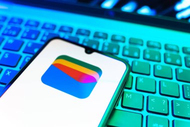 Prag, Çek Cumhuriyeti - 08 19 2025: Google Cüzdan logosunu gösteren klavyenin üzerinde duran cep telefonunun yakından görüntüsü. Google Cüzdanı dijital ödeme yöntemlerini depolamak ve kullanmak için bir platformdur.