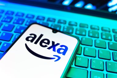 Prag, Çek Cumhuriyeti - 08 19 2025: Klavyenin üzerinde Alexa logosunu gösteren cep telefonunun yakın çekim görüntüsü. Alexa akıllı aygıtlar ve servisler için ses asistanıdır.