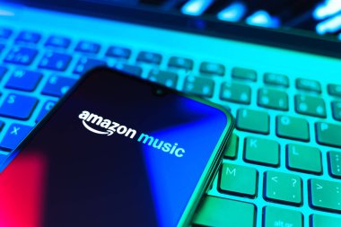 Prag, Çek Cumhuriyeti - 08 19 2025: Bir klavyenin üzerinde duran ve Amazon Müzik logosunu gösteren cep telefonunun yakından görüntüsü. Amazon Müzik müzik müzik için bir platformdur..