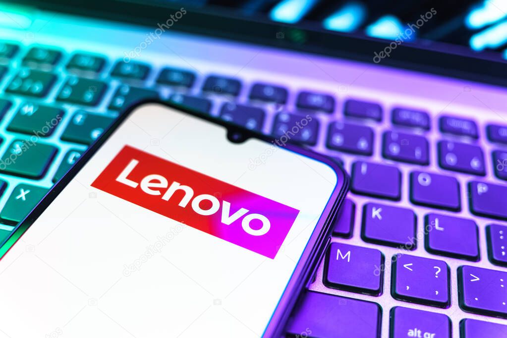 Prague, Czechia - 08 19 2025: A close-up view of a mobile phone lying on a keyboard, displaying Lenovo logo. Lenovo is a technology company producing computers and electronics.
