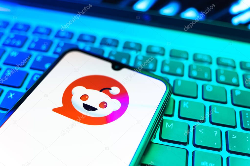 Prague, Czechia - 08 19 2025: A close-up view of a mobile phone lying on a keyboard, displaying Reddit logo. Reddit is a platform for discussion, news, and community content.