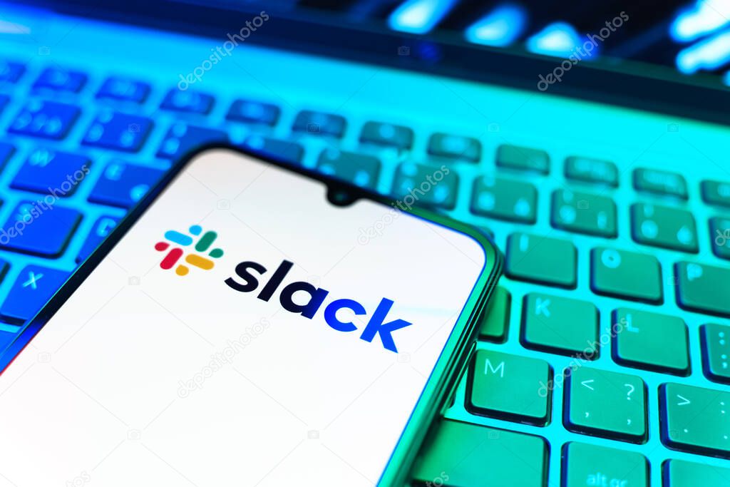 Prague, Czechia - 08 19 2025: A close-up view of a mobile phone lying on a keyboard, displaying Slack logo. Slack is a platform for team messaging and workplace communication.