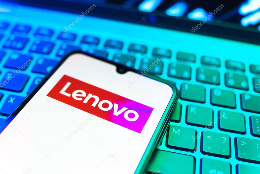 Prague, Czechia - 08 19 2025: A close-up view of a mobile phone lying on a keyboard, displaying Lenovo logo. Lenovo is a technology company producing computers and electronics.