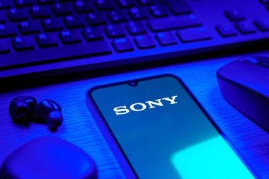 Prag, Çek Cumhuriyeti - 08 12 2025: Sony logosunu gösteren klavyesi ve cep telefonu olan bir masanın yan görüntüsü. Sony elektronik, oyun ve eğlence üreten bir teknoloji şirketidir..