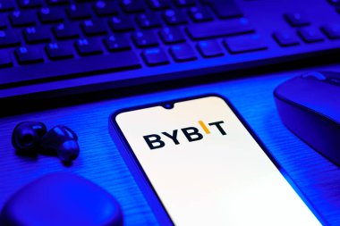 Prague, Czechia - 08 12 2025: A side view of a desk with a keyboard and a mobile phone displaying the Bybit logo. Bybit is a platform for trading cryptocurrencies and derivatives.