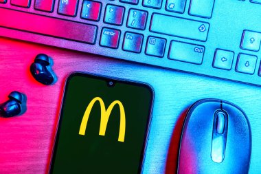 Prague, Czechia - 08 09 2025: A top-down view of a desk with a phone displaying the McDonalds logo. McDonalds is a fast-food chain serving burgers, fries, and more.