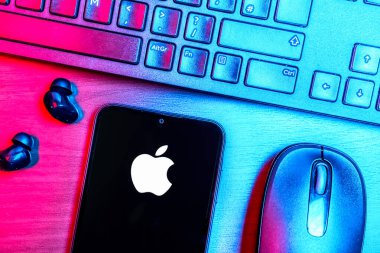 Prague, Czechia - 08 09 2025: A top-down view of a desk with a phone displaying the Apple logo. Apple is a technology company making iPhones, computers, and services.