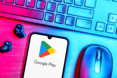 Prague, Czechia - 08 09 2025: A top-down view of a desk with a phone displaying the Google Play logo. Google Play is a platform for downloading apps, games, and digital content.