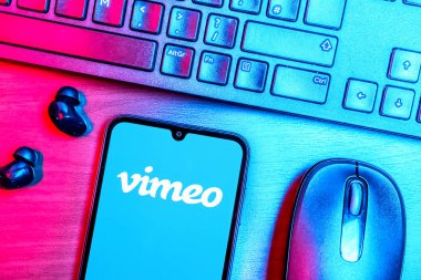 Prague, Czechia - 08 09 2025: A top-down view of a desk with a phone displaying the Vimeo logo. Vimeo is a platform for hosting and sharing high-quality videos.