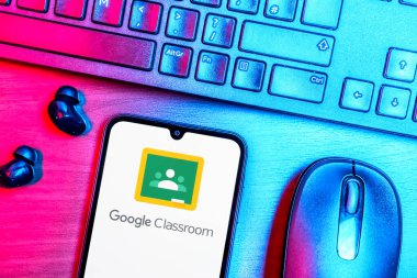 Prague, Czechia - 08 09 2025: A top-down view of a desk with a phone displaying the Google Classroom logo. Google Classroom is a platform for managing classes and educational content.