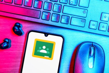Prague, Czechia - 08 09 2025: A top-down view of a desk with a phone displaying the Google Classroom logo. Google Classroom is a platform for managing classes and educational content.