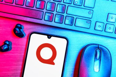 Prague, Czechia - 08 09 2025: A top-down view of a desk with a phone displaying the Quora logo. Quora is a platform for asking questions and sharing knowledge.
