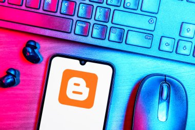 Prague, Czechia - 08 09 2025: A top-down view of a desk with a phone displaying the Blogger logo. Blogger is a platform for creating and publishing blogs.