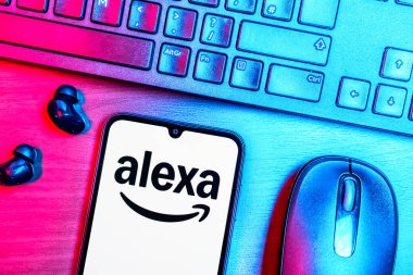 Prague, Czechia - 08 09 2025: A top-down view of a desk with a phone displaying the Alexa logo. Alexa is a voice assistant for smart devices and services.