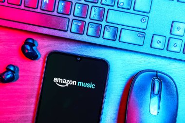 Prague, Czechia - 08 09 2025: A top-down view of a desk with a phone displaying the Amazon Music logo. Amazon Music is a platform for streaming and discovering music.