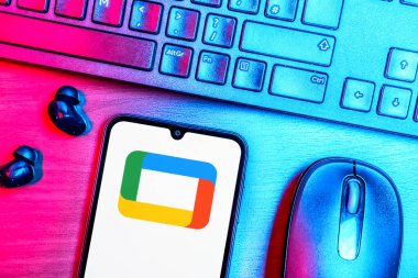 Prague, Czechia - 08 09 2025: A top-down view of a desk with a phone displaying the Google TV logo. Google TV is a platform for streaming movies, shows, and apps.