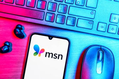 Prague, Czechia - 08 09 2025: A top-down view of a desk with a phone displaying the MSN logo. MSN is a platform for news, email, and online services.