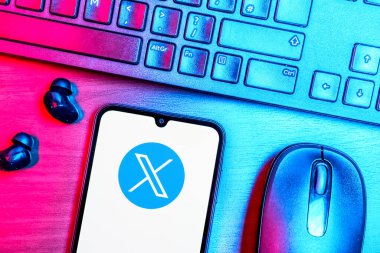 Prag, Çek Cumhuriyeti - 08 09 2025: X logosunu gösteren bir telefonun olduğu bir masanın yukarıdan görünüşü. X, kısa gönderileri ve güncellemeleri paylaşmak için bir platformdur.
