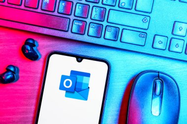 Prag, Çek Cumhuriyeti - 08 09 2025: Outlook logosunu gösteren bir telefonun olduğu bir masanın yukarıdan görünüşü. Outlook iletileri göndermek ve yönetmek için bir e- posta platformudur.