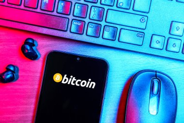 Prag, Çek Cumhuriyeti - 08 09 2025: Bitcoin logosunu gösteren bir telefonun olduğu bir masanın yukarıdan görünüşü. Bitcoin merkezi olmayan işlemler için dijital bir kripto para birimidir.