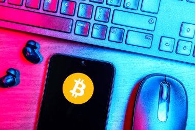 Prag, Çek Cumhuriyeti - 08 09 2025: Bitcoin logosunu gösteren bir telefonun olduğu bir masanın yukarıdan görünüşü. Bitcoin merkezi olmayan işlemler için dijital bir kripto para birimidir.