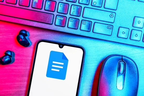 Prague, Czechia - 08 09 2025: A top-down view of a desk with a phone displaying the Google Docs logo. Google Docs is a platform for creating and editing text documents.