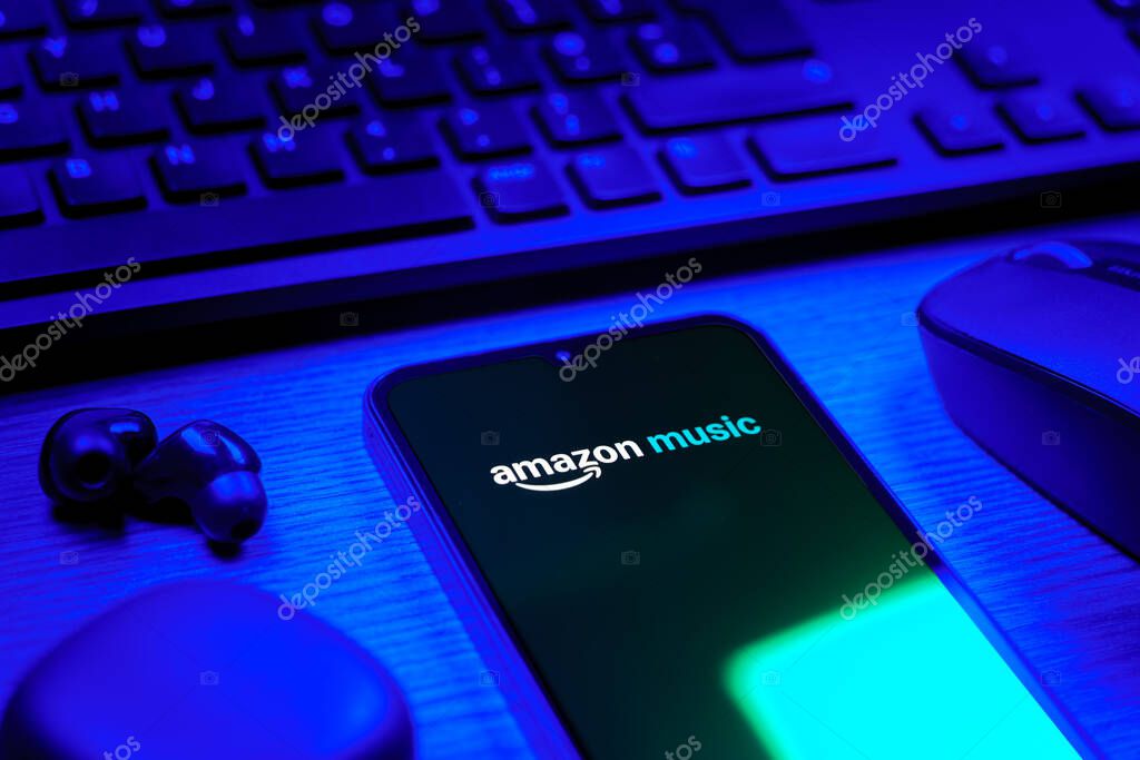 Prague, Czechia - 08 12 2025: A side view of a desk with a keyboard and a mobile phone displaying the Shazam logo. Shazam is an app for identifying songs and music tracks.