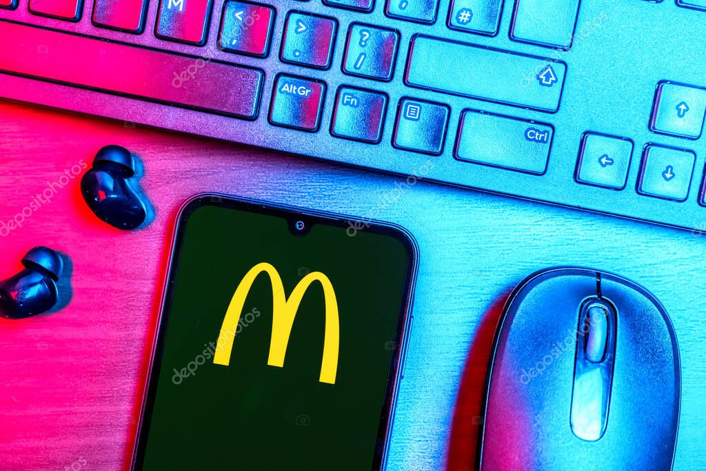 Prague, Czechia - 08 09 2025: A top-down view of a desk with a phone displaying the McDonalds logo. McDonalds is a fast-food chain serving burgers, fries, and more.