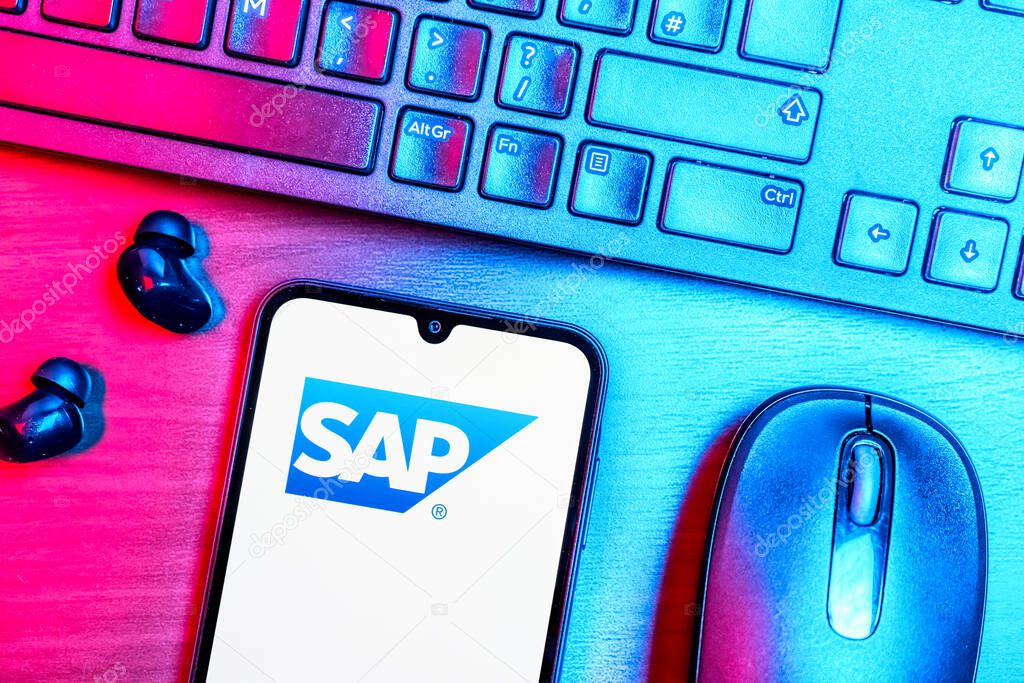 Prague, Czechia - 08 09 2025: A top-down view of a desk with a phone displaying the SAP logo. SAP is a software company providing enterprise applications and solutions.