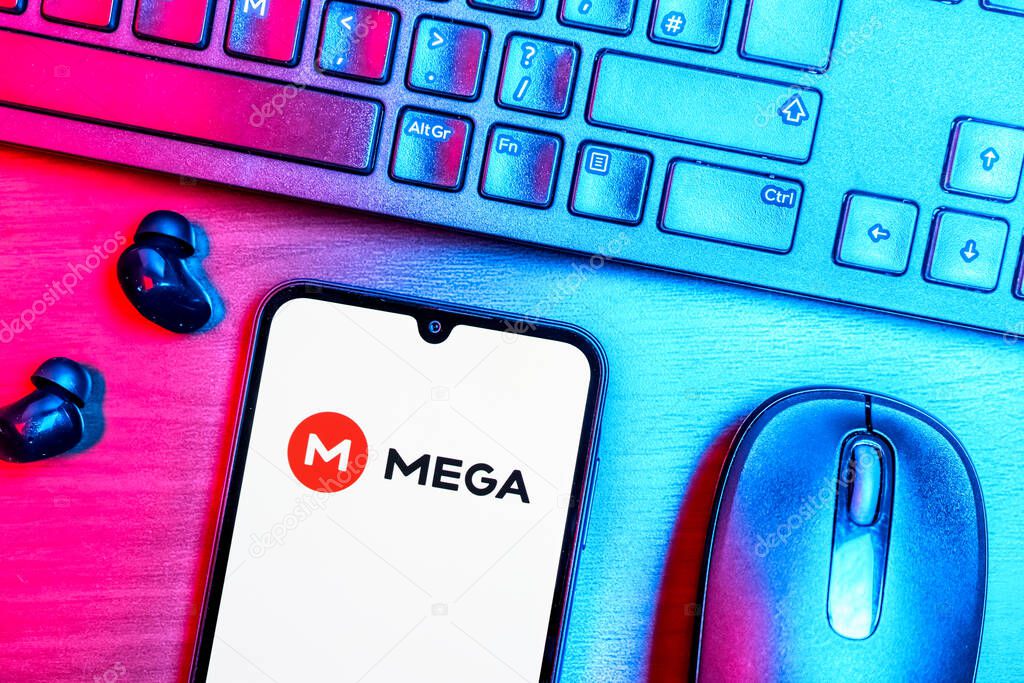 Prague, Czechia - 08 09 2025: A top-down view of a desk with a phone displaying the Mega logo. Mega is a platform for cloud storage with encrypted file sharing.