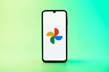Prag, Çek Cumhuriyeti - 08 10 2025: Tek tip arka planda duran bir cep telefonu Google Photos logosunu görüntüler. Google Fotoğrafları fotoğraf ve videoları saklamak ve düzenlemek için bir platformdur.