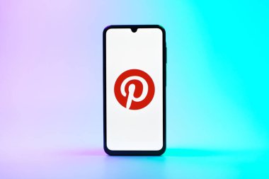 Prag, Çek Cumhuriyeti - 08 10 2025: Tek kullanımlık arka planda duran bir cep telefonu Pinterest logosunu gösteriyor. Pinterest fikirleri görsel olarak keşfetmek ve kaydetmek için bir platformdur..