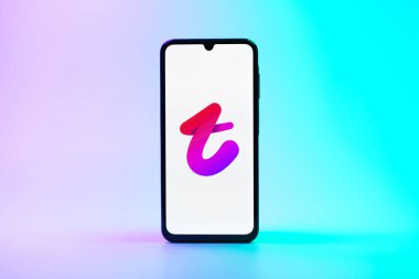 Prag, Çek Cumhuriyeti - 08 10 2025: Tek kullanımlık arka planda duran bir cep telefonu Tango logosunu gösteriyor. Tango, görüntülü aramalar, mesajlar ve canlı yayınlar için sosyal bir uygulama..