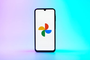 Prag, Çek Cumhuriyeti - 08 10 2025: Tek tip arka planda duran bir cep telefonu Google Photos logosunu görüntüler. Google Fotoğrafları fotoğraf ve videoları saklamak ve düzenlemek için bir platformdur.