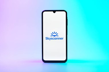 Prag, Çek Cumhuriyeti - 08 10 2025: Tek kullanımlık arka planda duran bir cep telefonu Skyscanner logosunu gösteriyor. Skyscanner uçak, otel ve araba kiralama araçlarını karşılaştırmak için bir platform..