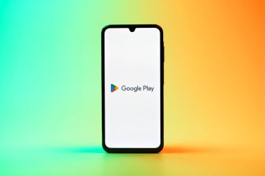 Prag, Çek Cumhuriyeti - 08 10 2025: Tek tip arka planda duran bir cep telefonu Google Play logosunu görüntüler. Google Play uygulamaları, oyunları ve dijital içeriği indirmek için bir platformdur.