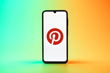 Prag, Çek Cumhuriyeti - 08 10 2025: Tek kullanımlık arka planda duran bir cep telefonu Pinterest logosunu gösteriyor. Pinterest fikirleri görsel olarak keşfetmek ve kaydetmek için bir platformdur..