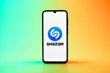 Prag, Çek Cumhuriyeti - 08 10 2025: Arka planda duran bir cep telefonu Shazam logosunu gösteriyor. Shazam şarkıları ve müzik parçalarını tanımlamak için bir uygulamadır.