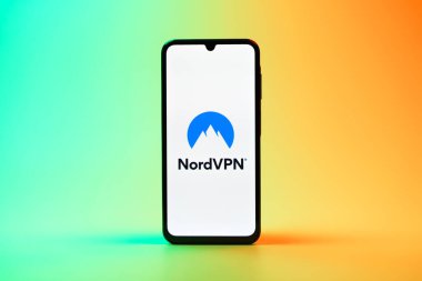 Prag, Çek Cumhuriyeti - 08 10 2025: Arka planda duran bir cep telefonu NordVPN logosunu gösteriyor. NordVPN güvenli ve özel internet taraması için bir platformdur.