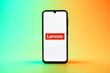 Prag, Çek Cumhuriyeti - 08 10 2025: Tek kullanımlık arka planda duran bir cep telefonu Lenovo logosunu gösteriyor. Lenovo bilgisayar ve elektronik üreten bir teknoloji şirketidir..