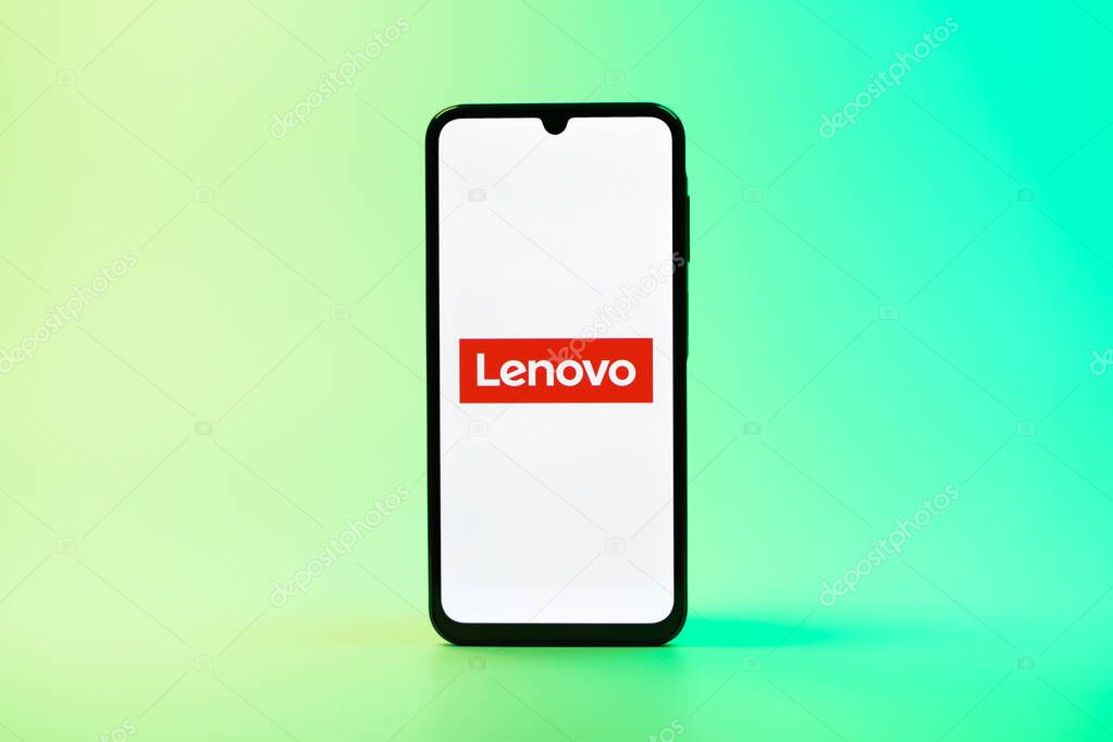 Prague, Czechia - 08 10 2025: A mobile phone standing on a uniform background displays the Lenovo logo. Lenovo is a technology company producing computers and electronics.